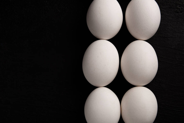 Siyah arka planda beyaz tavuk yumurtaları. Çiftlik ürünleri. Doğal yumurtalar. Tavuk yumurtaları masada. - Fotoğraf, Görsel