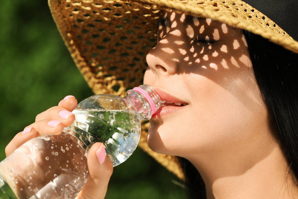 Beautiful young woman drinking water outdoors, closeup. Refreshing drink - Foto, Bild