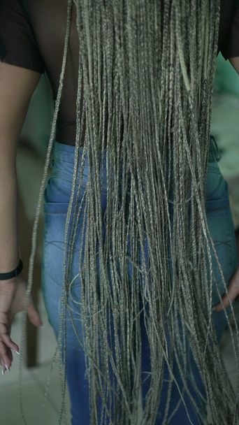 A black latina girl with dreadlocks hair. An African woman plays with box braids hairstyle - Foto, imagen