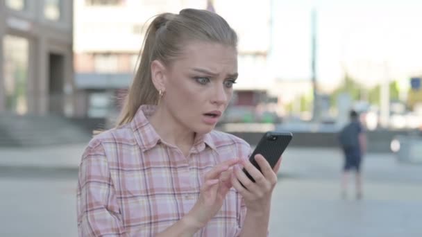 Upset Casual Woman Reacting to Loss on Smartphone Outdoor - Filmati, video
