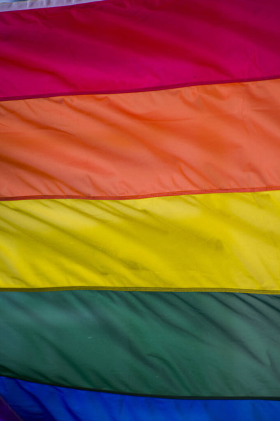 Lähikuva sateenkaari homo ylpeys lippu ulkona kadulla. Symboli Lesbo Biseksuaali Transsukupuolinen LGBT yhteisö vilkuttaa tuulessa vastaan pilvinen taivas. Sosiaalinen liikkuvuus vapauden ja tasa-arvon puolesta. Kopioi tila  - Valokuva, kuva