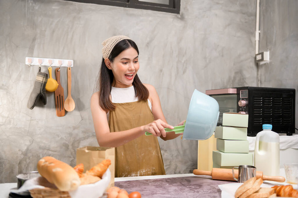 A Young beautiful woman is baking in her kitchen , bakery and coffee shop business - Photo, image