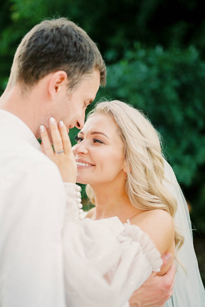 Smiling bride touches groom cheek with her hand. Portrait. High quality photo - Φωτογραφία, εικόνα