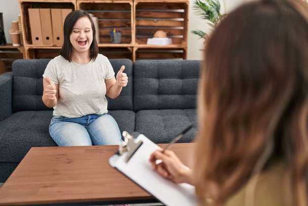 Hispanic girl with down syndrome doing therapy success sign doing positive gesture with hand, thumbs up smiling and happy. cheerful expression and winner gesture.  - Foto, Imagen