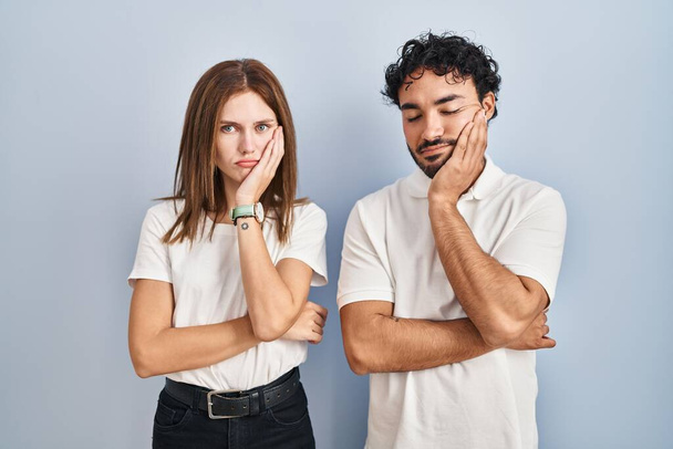 Young couple wearing casual clothes standing together thinking looking tired and bored with depression problems with crossed arms.  - Valokuva, kuva
