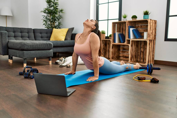 Young woman having online stretching class at home - Foto, Imagen