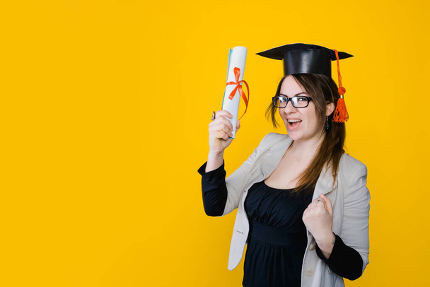 Portrait of graduate girl on bright yellow background, copy space - Photo, Image