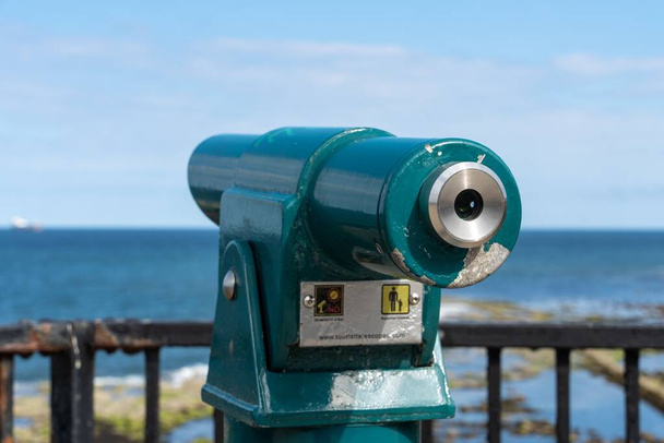 Туристический телескоп или телескоп на берегу моря в Уитли-Бей, Великобритания, напоминающий о посещении моря. - Фото, изображение
