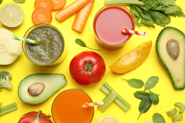 Delicious juices and fresh ingredients on yellow background, flat lay - Photo, image