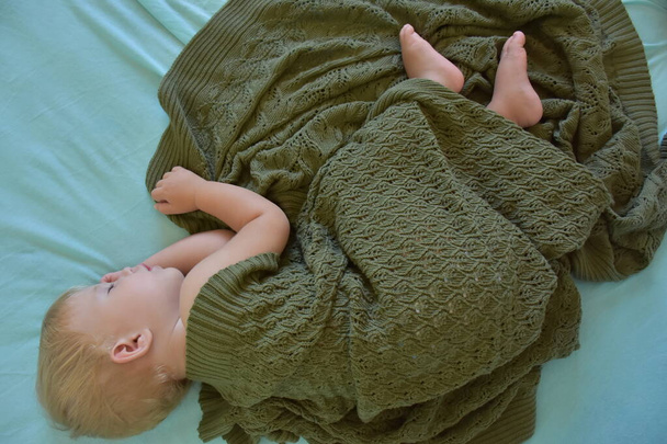 baby sleeping and knitted blanket - Fotó, kép
