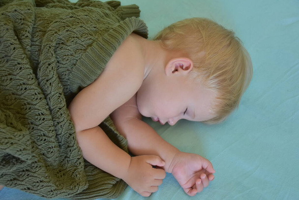 baby sleeping and knitted blanket - Fotó, kép