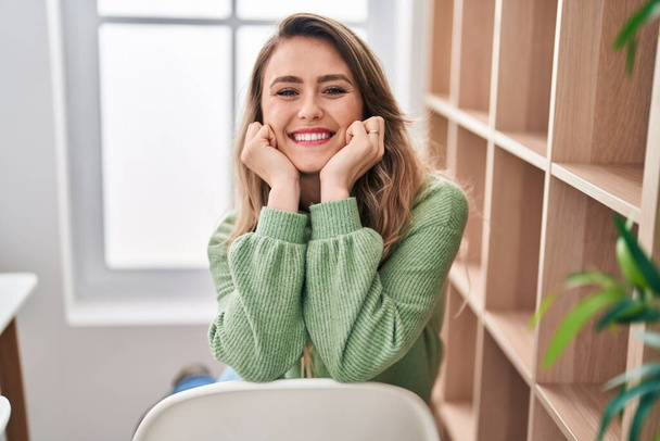 Young woman smiling confident sitting on chair at home - Photo, Image