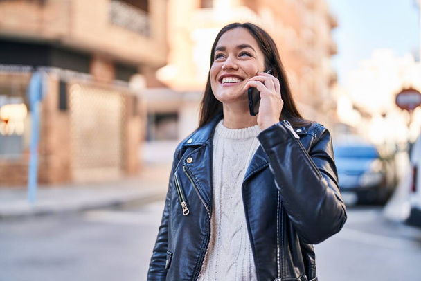 Nuori nainen hymyilee luottavainen puhuu älypuhelimeen kadulla - Valokuva, kuva