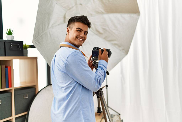 Fiatal spanyol férfi fotós professzionális fényképezőgép a fotózás stúdió - Fotó, kép