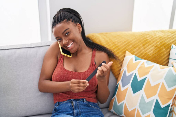Africano americano mulher falando no smartphone fazendo manicure em casa - Foto, Imagem