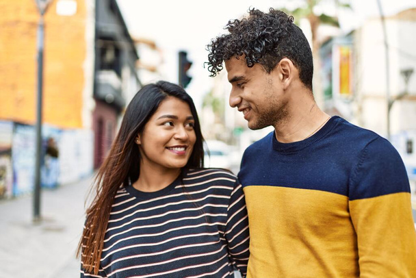 Jovem casal latino sorrindo feliz e abraçando a cidade. - Foto, Imagem