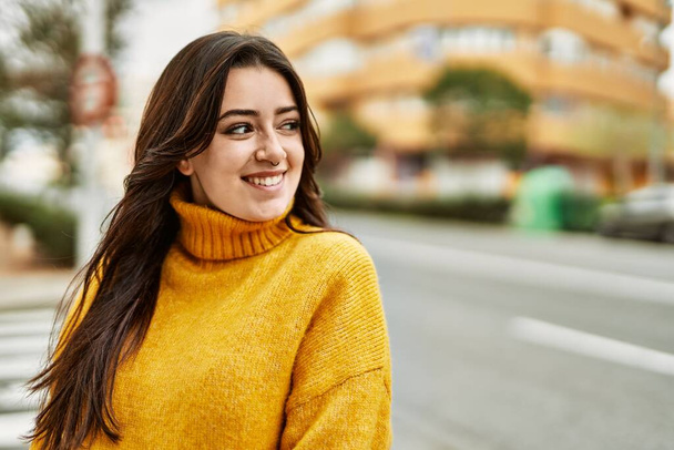Young beautiful brunette woman wearing turtleneck sweater smiling happy outdoors - Photo, Image
