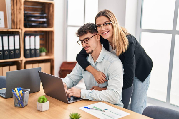 Молодий чоловік і жінка бізнесмен обіймають один одного, працюючи в офісі
 - Фото, зображення