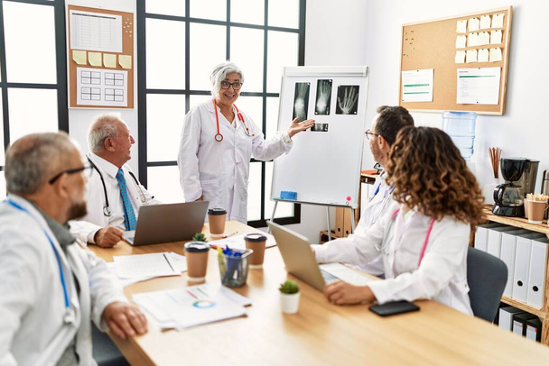 Група лікарів середнього віку обговорює медичну нараду в клінічному кабінеті
. - Фото, зображення