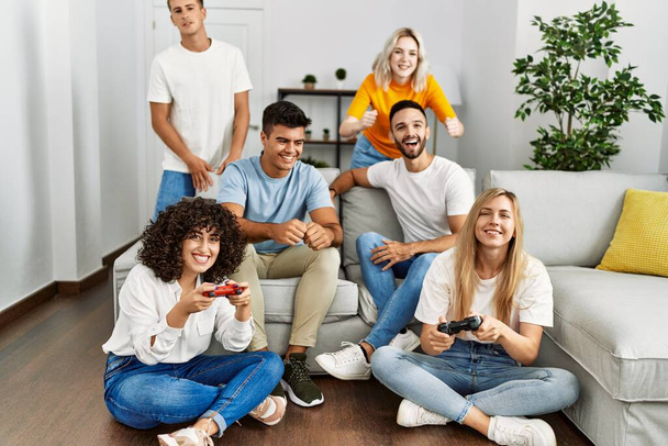 Група молодих друзів посміхається щаслива гра в відеоігри вдома
. - Фото, зображення