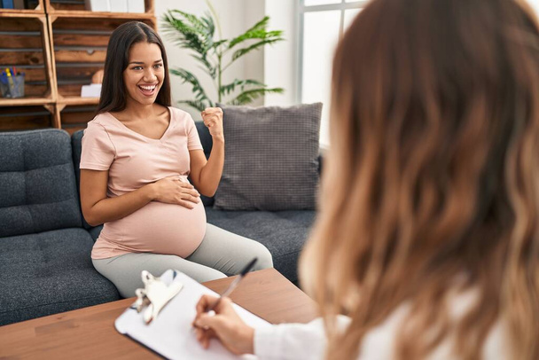 Fiatal terhes nő terápiás ülésen sikoltozó büszke, ünneplő győzelem és a siker nagyon izgatott felemelt karokkal  - Fotó, kép