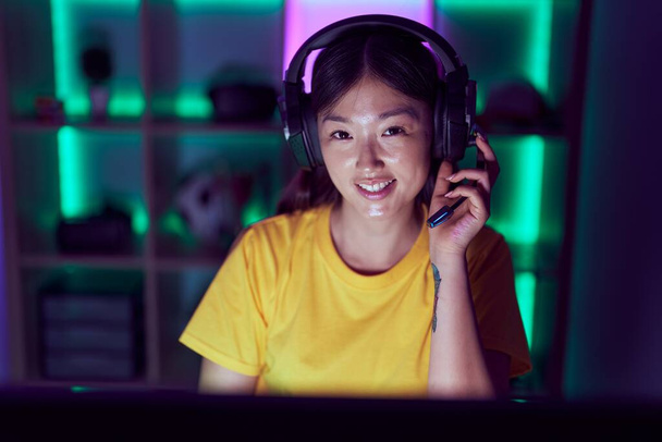 Kiinalainen nainen serpentiini hymyilee luottavainen tietokoneella pelihuoneessa - Valokuva, kuva