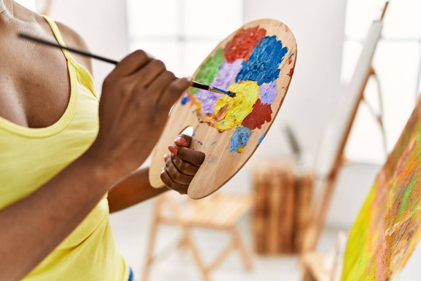Mujer artista afroamericana mezclando color en paleta en el estudio de arte. - Foto, Imagen