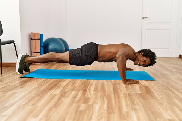 Jeune homme afro-américain formation push-ups à la salle de gym - Photo, image