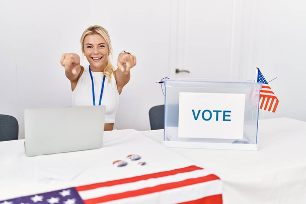 Νεαρή λευκή γυναίκα στις εκλογές της αμερικανικής πολιτικής εκστρατείας που δείχνει εσένα και την κάμερα με τα δάχτυλα, χαμογελαστή θετική και χαρούμενη  - Φωτογραφία, εικόνα