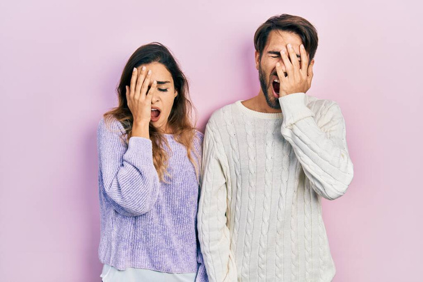 Young hispanic couple wearing casual clothes yawning tired covering half face, eye and mouth with hand. face hurts in pain.  - Valokuva, kuva