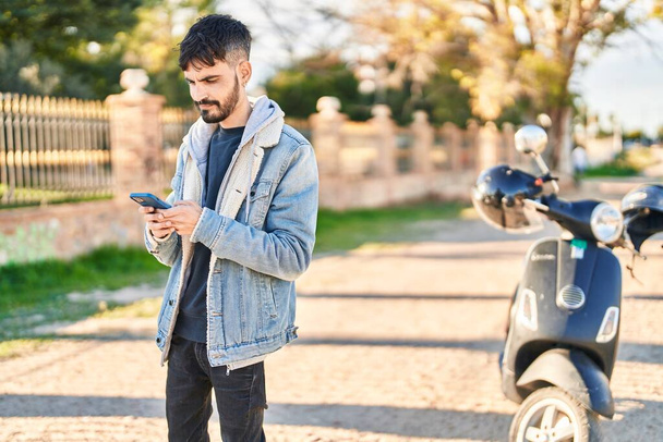 Young hispanic man using smartphone at street - Foto, imagen
