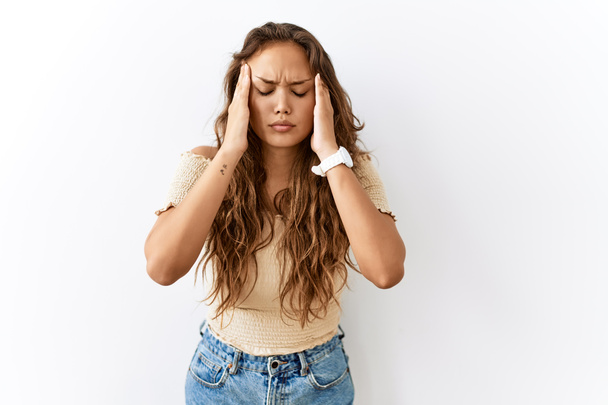 Krásná hispánská žena stojí nad izolované zatímco pozadí s rukou na hlavě pro bolest hlavy, protože stres. trpící migréna.  - Fotografie, Obrázek