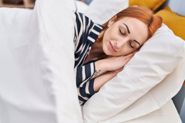 Giovane donna caucasica sdraiata sul letto dormire in camera da letto - Foto, immagini