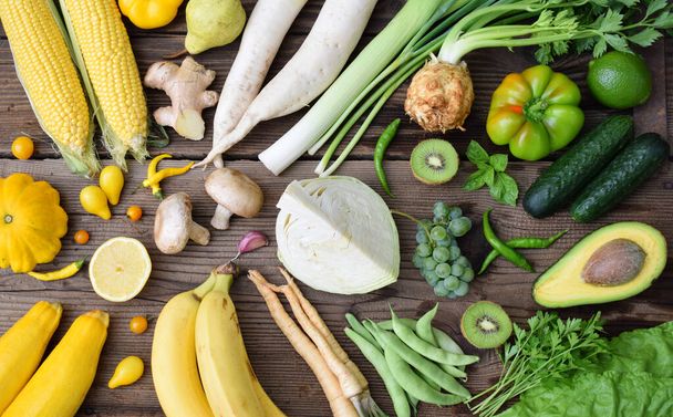 White, green, yellow fruits and vegetables on wooden background.  Healthy food. Multicolored raw food. - Фото, зображення