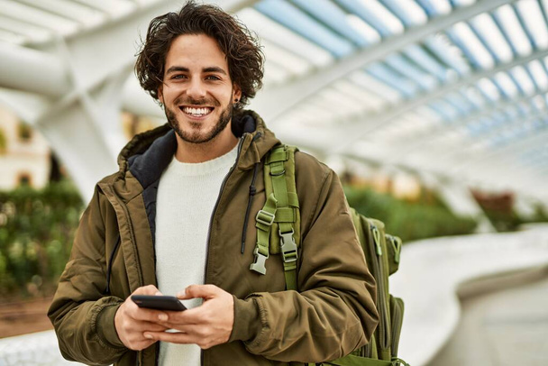Knappe Spaanse man met smartphone in de stad - Foto, afbeelding