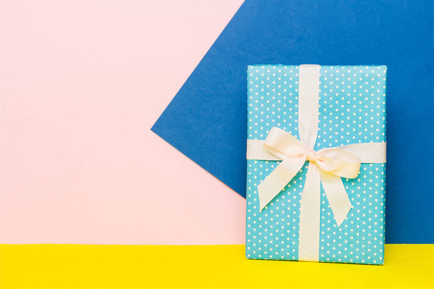 holiday paper present tied yellow ribbon bow top view with copy space. Flat lay holiday background. Birthday or christmas present. Christmas gift box concept with copy space. - 写真・画像