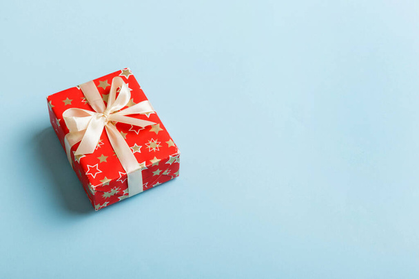 Csomagolt karácsonyi vagy más ünnep kézzel készített ajándék papírba színes szalaggal. Jelen doboz, ajándék dekoráció az asztalon, felülnézet másolási hellyel. - Fotó, kép