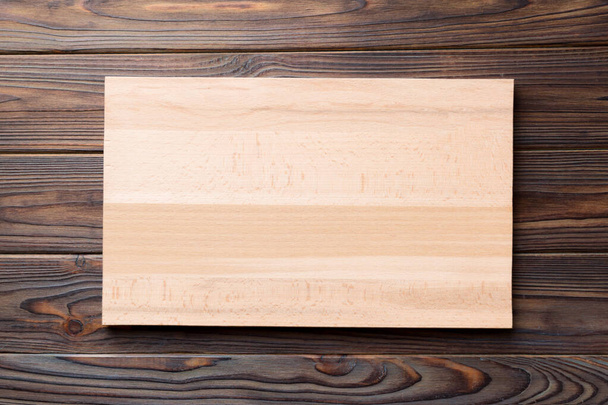 Top view of wooden cutting board on cement background. Empty space for your design. - Φωτογραφία, εικόνα