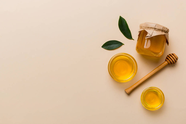 Frasco de mel com mergulhador de mel de madeira no fundo branco vista superior com espaço de cópia. Frasco de mel delicioso. - Foto, Imagem