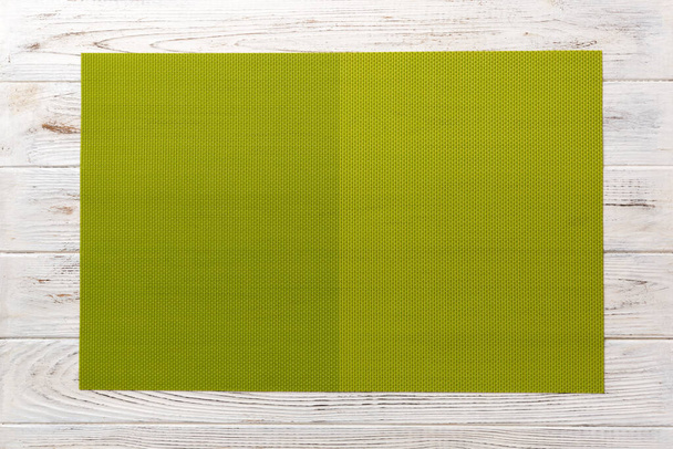 Верхний вид зеленой скатерти для еды на деревянном фоне. Пустое место для дизайна
. - Фото, изображение