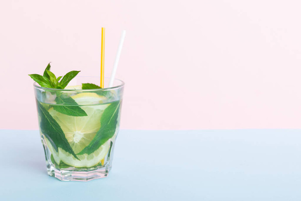 Mojito καλοκαιρινό δροσιστικό κοκτέιλ με πάγο και μέντα. mojito cocktail με lime, λεμόνι και μέντα σε ψηλό ποτήρι με stick. - Φωτογραφία, εικόνα