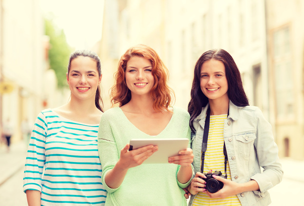 smiling teenage girls with tablet pc and camera - Photo, image