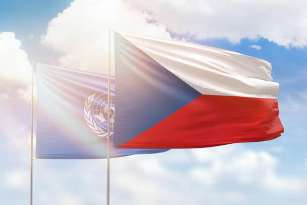 Sunny blue sky and flags of czechia and united nations - Photo, image