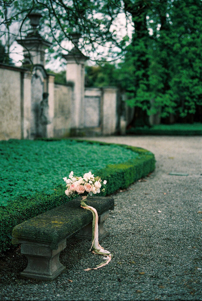 Wedding bouquet stands on a stone bench in the park. Lake Como, Italy. High quality photo - 写真・画像