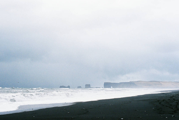 Black sand of Reynisfjara beach on the seashore. Iceland. High quality photo - Fotó, kép