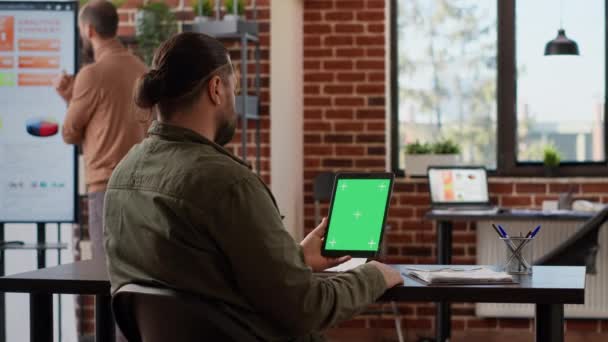 Podnikatel se dívá na digitální tablet se zeleným displejem v kanceláři firmy. Použití izolované prázdné šablony copyspace s pozadí chroma klávesy a mockup na bezdrátové gadget. - Záběry, video