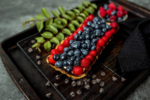 Fruit Tart full of Berries with chocolate and cream on cookie crust. European dissert. - Foto, Bild