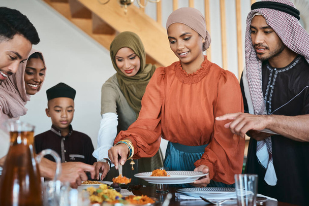 Fill up your plate. a muslim family dishing lunch for themselves - Valokuva, kuva
