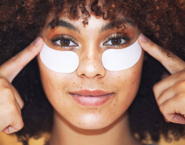 Theres a solution for those fine line. a beautiful young woman wearing under-eye gel patches as part of her skincare routine - 写真・画像