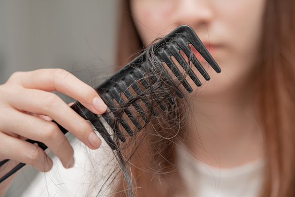 Asian woman have problem with long hair loss attach to comb brush. - Foto, Imagen